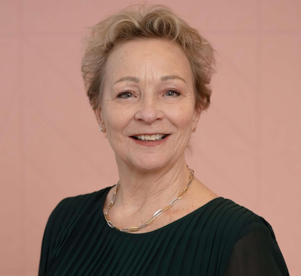 Marja Hofland tegen een roze achtergrond