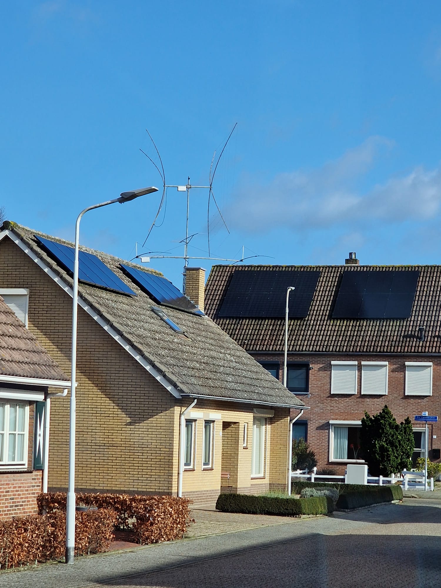 Zendamateur in Sint Jansteen, antenne die boven de daken van huizen uit steekt
