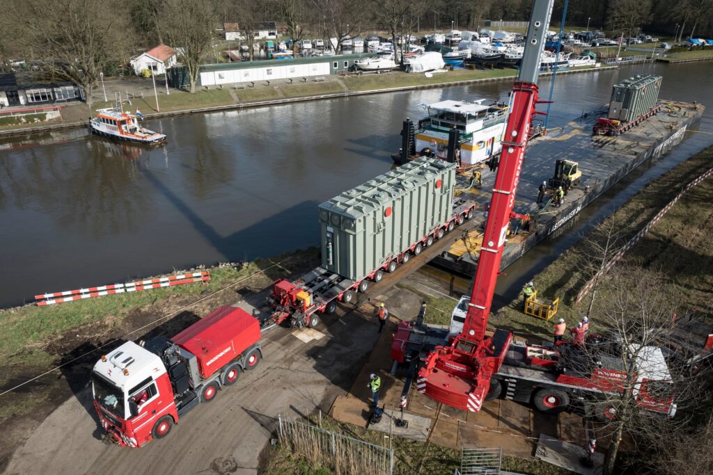 De transformatoren worden gelost van het binnenvaartschip.