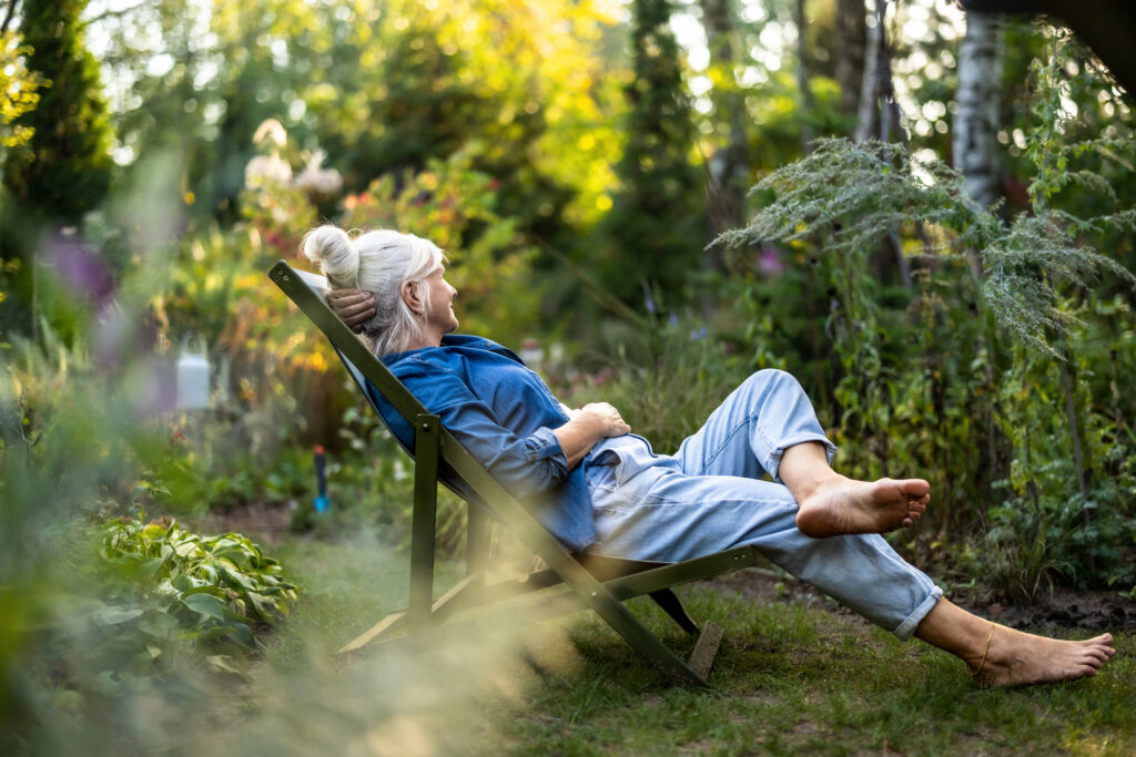 Vrouw ontspant in een groene tuin, symbool voor leefkwaliteit en welzijn