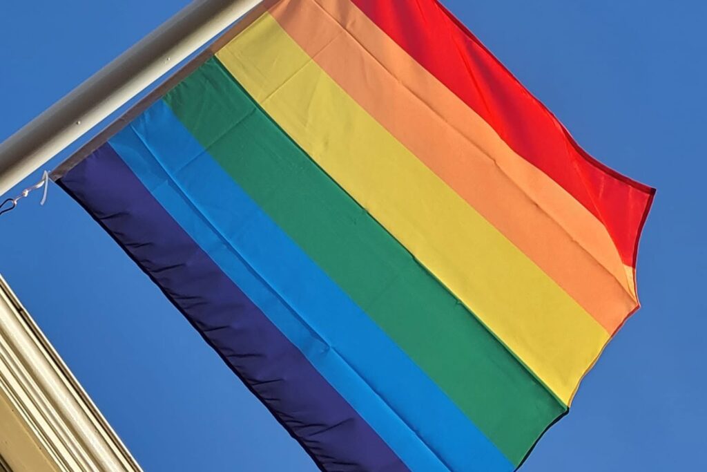 Regenboogvlag tegen een blauwe lucht